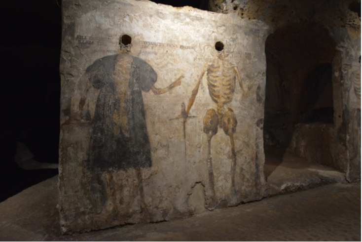 two skeletons entombed in the wall, their alive body painted on the wall